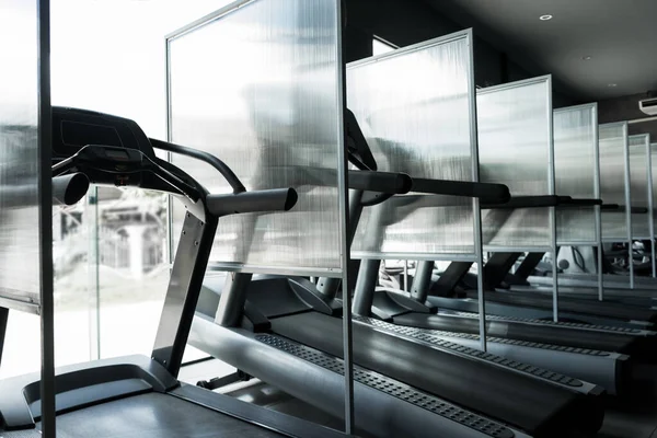 GYM ya da FITNESS 'in yeni normali. Covid 19 veya Coronavirus hastalığının yayılmasını önlemek için elektrik koşu bandının yanında bölme. Yeni normal egzersiz kavramı.