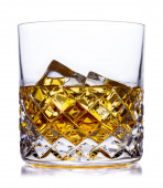 Křišťálová sklenice se skotskou whisky a ledem, broušená na bílém s malým odrazem
