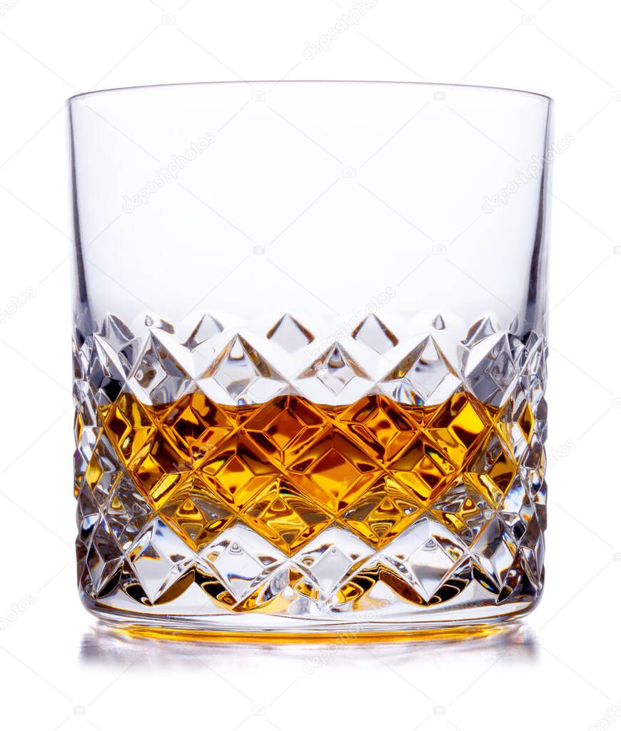 A crystal glass containing scotch whisky shot on white, with a drop shadow