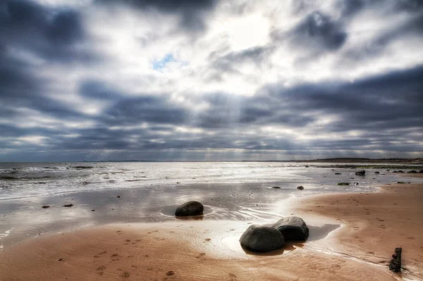 Storm clouds before the calm on a sandy beach of the north east coast of the UK