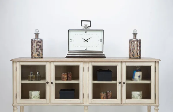 白色底座上的玻璃幕墙 餐具柜 装饰品和一个大钟 — 图库照片