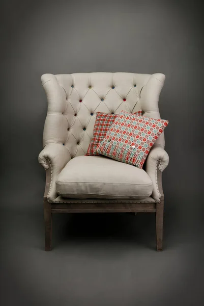 灰色背景的扶手椅和两个彩色靠垫 — 图库照片