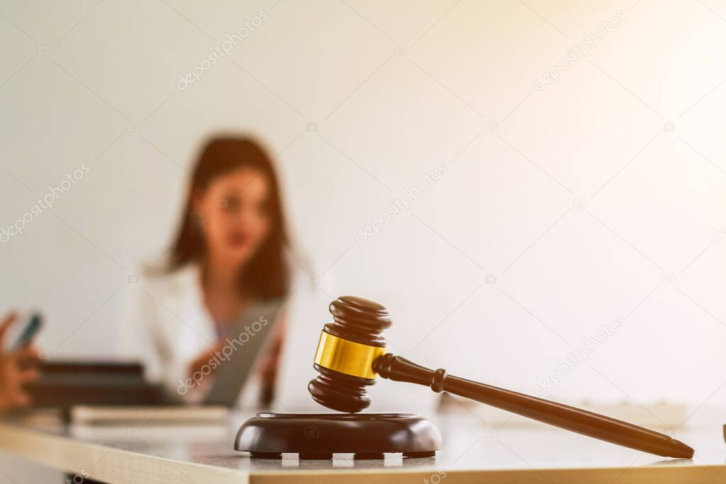 Wooden gavel is placed on the table in the notary office, Wooden gavel used to knock during a court decision. The legal team is currently providing advice and consulting within the law firm.