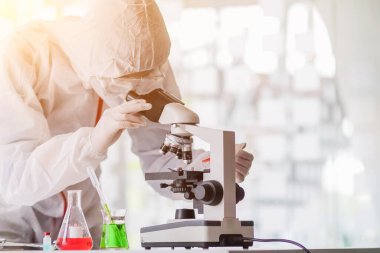 Görüntü bulanıklığı, tıbbi ekip koronavirüs koruyucu giysi ve lastik eldiven giyerek Coronavirus covid-19 'u inceledi ve salgını durdurmak için koronavirüs covid-19 aşısını araştırdı..
