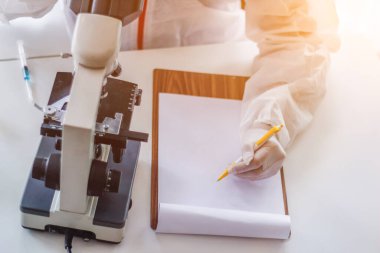 Sağlık ekibi Coronavirus Covid-19 'u incelemek ve salgını durdurmak için Coronavirus Covid-19 aşısını araştırmak için bir koronavirüs koruyucu giysisi ve lastik eldiven giydi..