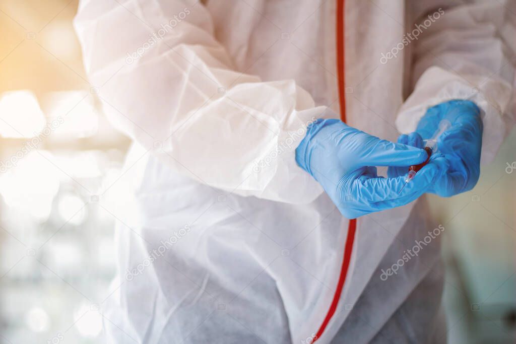 Medical scientists are wearing coronavirus protective clothing and rubber gloves before entering the lab for examination of coronavirus. covid-19 and research for a vaccine against coronavirus covid19