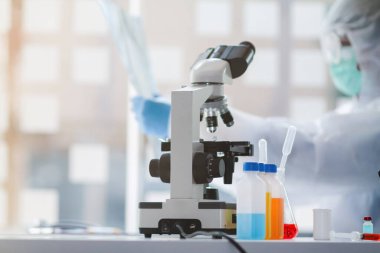 Sağlık ekibi Coronavirus Covid-19 'u incelemek ve salgını durdurmak için Coronavirus Covid-19 aşısını araştırmak için bir koronavirüs koruyucu giysisi ve lastik eldiven giydi..