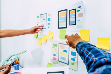 Web sitesi tasarımcılarından oluşan bir ekip, akıllı telefonun ön tarafındaki ux ui sistemi ile görüntüleme biçimini belirlemek için programlar yazıyorlar ve katman oluşturuyorlar..