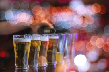 Yumuşak Işık ve Yumuşak Odaklanma, genç kadın başarıyı kutlayan müşterilere servis yapmak için bardakların üzerine bira doldurdu. Rahatlamak için alkol ya da bira içme fikri.