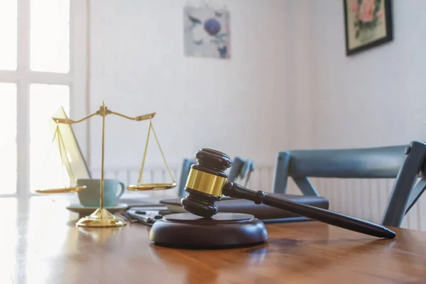 The mallet and brass scales are placed on the table in the lawyer\'s office for decorative purposes and are a symbol of justice in court decisions.