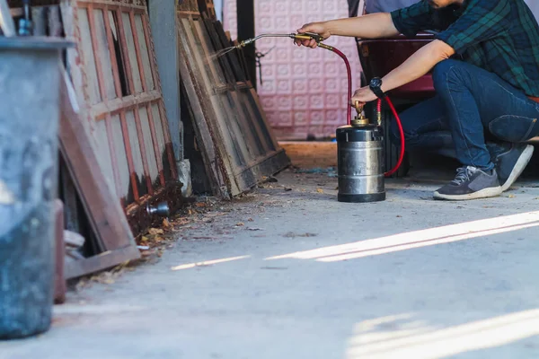 一家白蚁控制公司的员工正在使用化学喷雾器清除顾客家中的白蚁 并搜寻白蚁巢以根除它们 预防昆虫的化学喷雾方法 — 图库照片