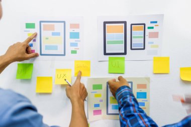 Web sitesi tasarımcılarından oluşan bir ekip, akıllı telefonun ön tarafındaki ux ui sistemi ile görüntüleme biçimini belirlemek için programlar yazıyorlar ve katman oluşturuyorlar..