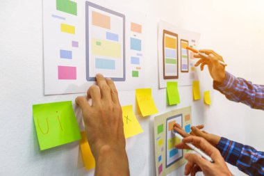 Web sitesi tasarımcılarından oluşan bir ekip, akıllı telefonun ön tarafındaki ux ui sistemi ile görüntüleme biçimini belirlemek için programlar yazıyorlar ve katman oluşturuyorlar..