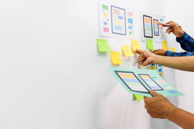Web sitesi tasarımcılarından oluşan bir ekip, akıllı telefonun ön tarafındaki ux ui sistemi ile görüntüleme biçimini belirlemek için programlar yazıyorlar ve katman oluşturuyorlar..