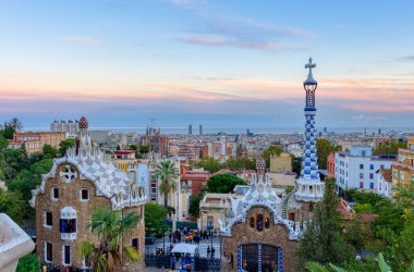 Gün batımında Park Guell 'den Barselona manzarası. Ön planda ana girişin renkli binaları var. Barselona, İspanya.