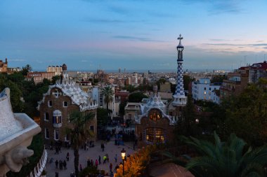 Gün batımında Park Guell 'den Barselona manzarası. Ön planda ana girişin renkli binaları var. Barselona, İspanya.