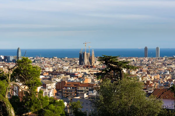Barcelona, İspanya - 02 Kasım 2018: Parc Guell terasından Barcelona 'nın çatılarının görüntüsü. Kenarda La Sagrada Familia, arkada da deniz. Barselona, İspanya.