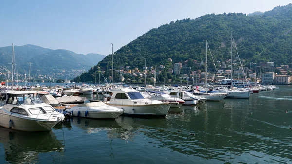 Gemiler Como Gölü 'ne demirlemiş, arkada dağlar, İtalya