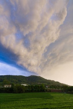 Yeşil tepede fırtına öncesi tehditkar bulutlar