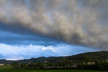 Yeşil tepede fırtına öncesi tehditkar bulutlar