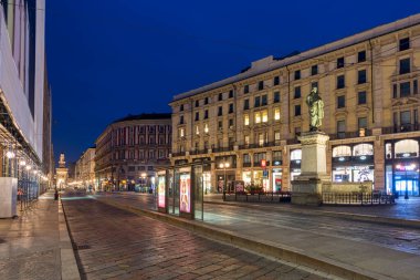 Milan, İtalya - 18 Mart 2017: Alacakaranlıkta Piazza Cordusio, arkada Sforza Kalesi, Giuseppe Parini Anıtı 'nın sağında