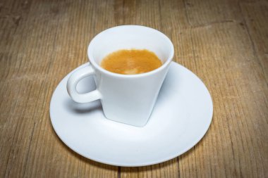 Beyaz espresso bardağını eski ahşap masaya kapatın.