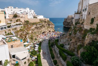 Polignano a Mare, İtalya - 11 Ağustos 2017: İtalya 'nın güneyindeki Puglia sahil kasabası Polignano a Mare' de Akdeniz 'de yıkanan insanlar.