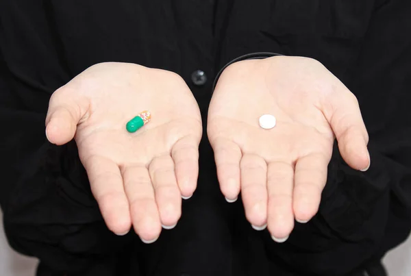 In the hands of two different pills. Choice of medicine or vitamins. Drink vitamins or get sick.