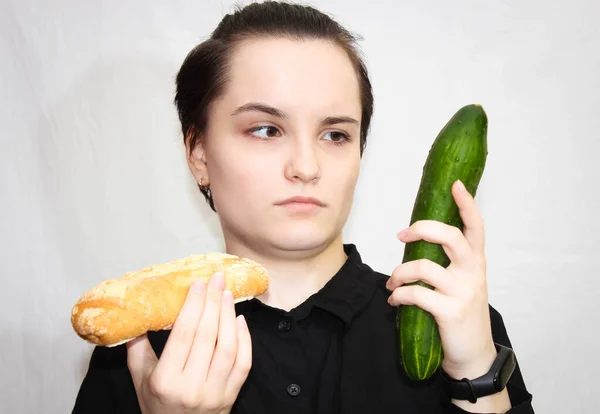 Young Girl Thoughtful Face Cucumber Bun Her Hands Choice Food — Stock Photo, Image