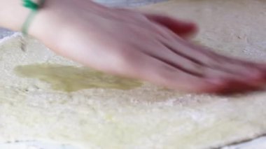 Bir kadının eli mantar hamuruna sebze yağı sürer. Evde ekmek pişirmek için..