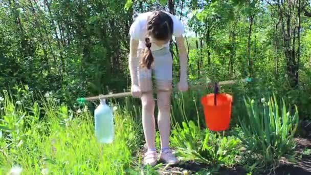 Μια Έφηβη Κάνει Ασκήσεις Στον Κήπο Τσουγκράνα Αντί Για Βαρελάκι — Αρχείο Βίντεο