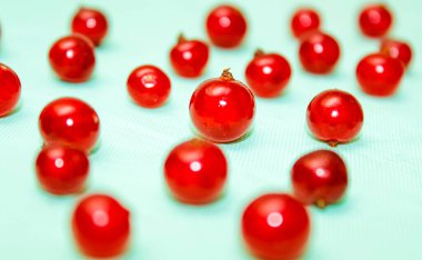 Mavi arka planda kırmızı frenk üzümü, kenarlarda bulanık çerçeve. Taze duttan yapılmış bir şablon. Seçici atış.