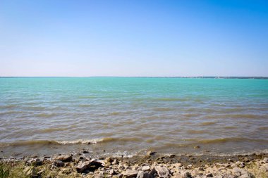 Yazın güneşli bir günde kumsal ve turkuaz göl. Peyzaj.