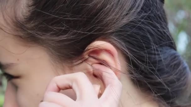 Teenage Girl Street Scratches Her Left Ear Close — Stock Video