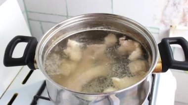 Gaz ocağındaki bir tencerede, haşlanmış et çorbası pişirilir. Evde yemek pişirmek..