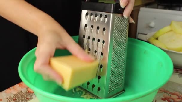 キッチンの女性がハードチーズをカップにすりおろす クローズアップ 選択的ショット — ストック動画
