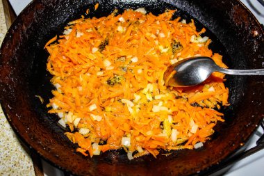 Kızartma tavasında soğanlı kızarmış havuç. Et için lezzetli sebze sosu. Yukarıdan görünüşü.