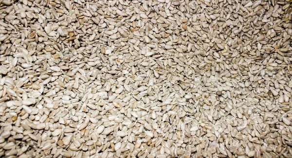 Peeled sunflower seeds are piled in a pile. Feed for farm birds. Close-up, background.