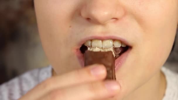 Молода Дівчина Кусає Жує Шоколадні Цукерки Крупним Планом — стокове відео
