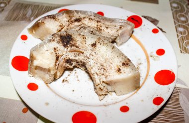 Bir tabakta kaynamış domuz yağı, üzerine karabiber serpilmiş. Kapat.