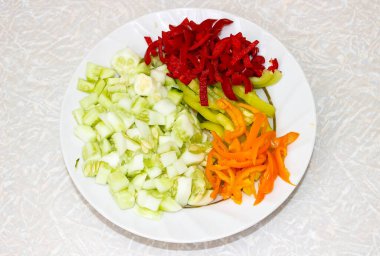 Masada ince doğranmış sebzelerle birlikte bir tabak. Yakın çekim, seçici odaklanma.