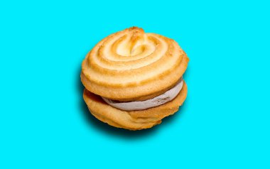 Doldurulmuş duble kurabiye. Kurabiyeli sandviç. Bir gölgeyle mavi bir arkaplanda izole edilmiş.