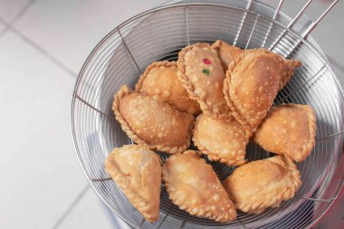 Beyaz tabakta körili puf. Körili börek, abur cubur, hamur işi, dolma çörek..