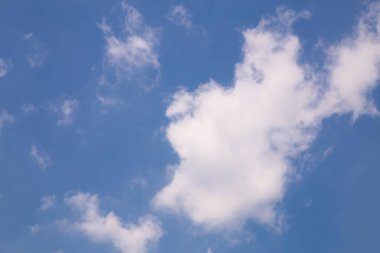 Arkadaki mavi gökyüzünde güzel beyaz bulutlar