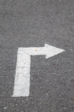 Kırık asfalt yüzeyinde beyaz ok. Trafiği kavra, asfalt üzerinde çatırdayan desenli trafik oku