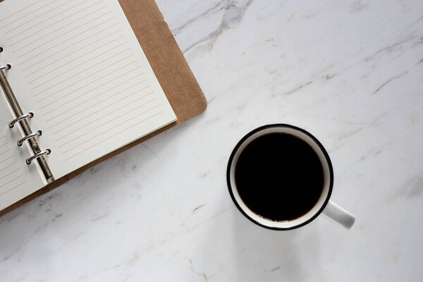 image of a coffee cup, note book and pen with coffee beans on Natural marble white & cream