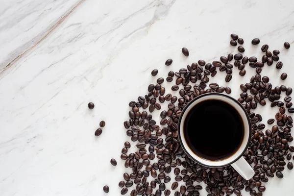 Schwarzer Kaffee Mit Gerösteten Bohnen Auf Weißem Marmor — Stockfoto