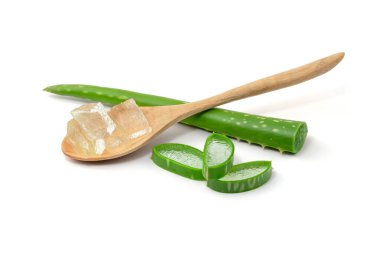 Su damlaları Aloe Vera 'yı (Aloe barbadensis Mill, Star cactus, Aloe, Aloin, Jafferabad veya Barbados) keser ve kesme yolu olan beyaz bir arka planda izole edilmiş ahşap kaşığa jel sürer.
