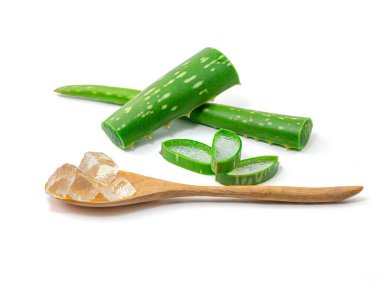 Su damlaları Aloe Vera 'yı (Aloe barbadensis Mill, Star cactus, Aloe, Aloin, Jafferabad veya Barbados) keser ve kesme yolu olan beyaz bir arka planda izole edilmiş ahşap kaşığa jel sürer.