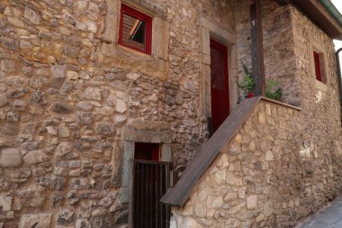 Pencereleri kırmızı olan ev cephesi